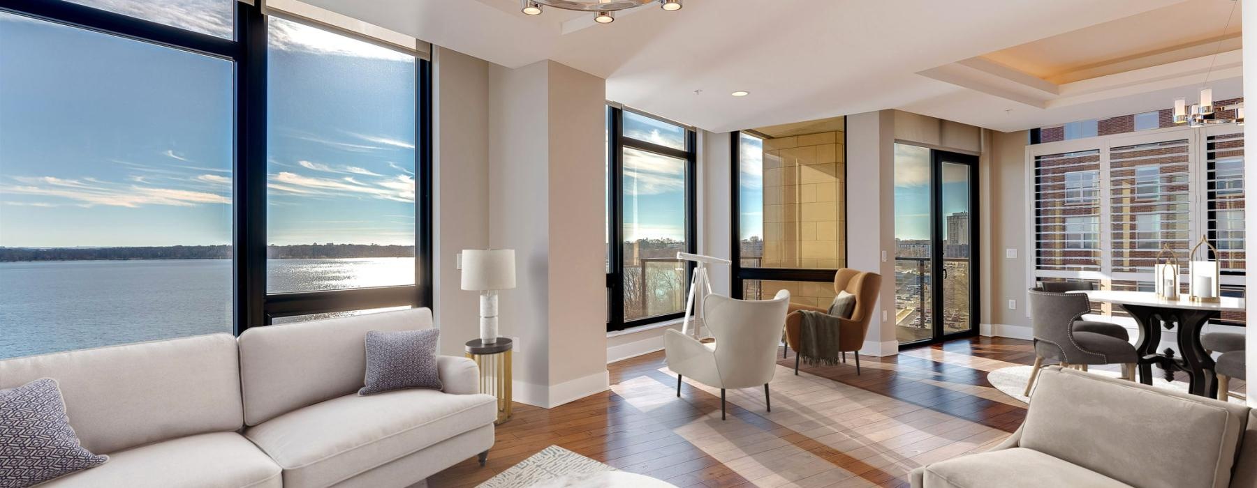 a large living room with large windows overlooking a lake