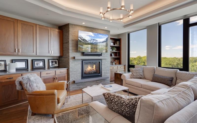 a lounge with a fireplace tv and large windows